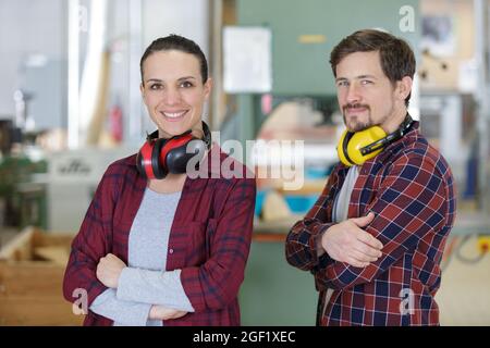 portrait des travailleurs masculins et féminins portant des couvre-oreilles autour du cou Banque D'Images
