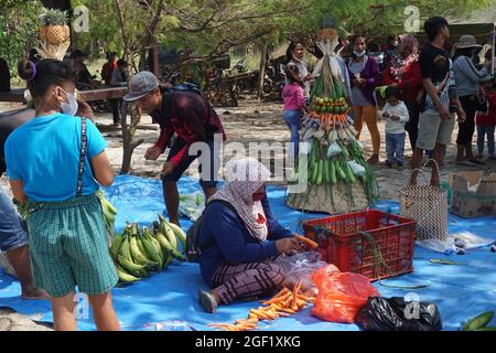 Les gens organisent des légumes pour faire le tumpeng sayur (cône de légumes) pour la cérémonie de la sedekah bumi (action de grâce javanaise) à la plage de sanggar Banque D'Images