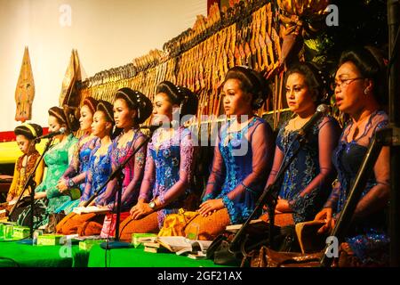 Les sinden qui étaient à l'ombre du spectacle de marionnettes. Ce sont des chanteurs traditionnels dont le travail est de chanter des chansons demandées par un dalang pendant les performances. Banque D'Images