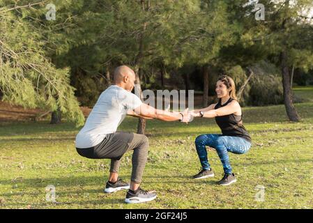 Faites de l'exercice au couple en tenant les mains dans le parc Banque D'Images