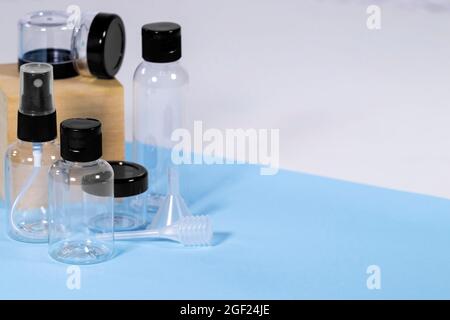 Groupe de bouteilles de voyage en plastique transparent pour cosmétiques : savon, gel, lotion, crème, shampooing, Maquillage et liquides sur fond bleu clair. Voyages modernes Banque D'Images