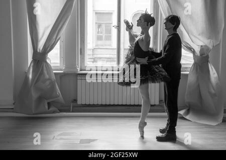 Une jeune ballerine vêtue d'un tutu noir reçoit des conseils d'un maître de ballet pour répéter une représentation à Saint-Pétersbourg Banque D'Images