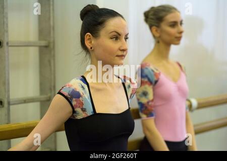 Trois ballerines pratiquent leur routine dans le corps de ballet pour une représentation de Swan Lake à Saint-Pétersbourg, en Russie Banque D'Images