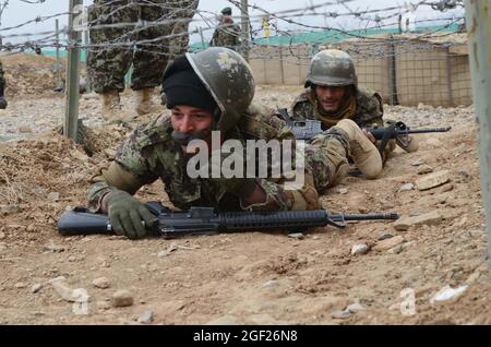 PROVINCE de PAKTYA, Afghanistan – les stagiaires de base de l’Armée nationale afghane se débaissent sous des barbelés lors d’un cours d’obstacles au Centre régional d’instruction militaire de Gardez, le 25 février 2013. Les stagiaires de base en sont actuellement à la sixième semaine d'un cours de neuf semaines et seront diplômés à la fin de mars 2013. (É.-U. Photo de l'armée par la SPC. Tianna Waite, 115e Détachement mobile des affaires publiques) Banque D'Images