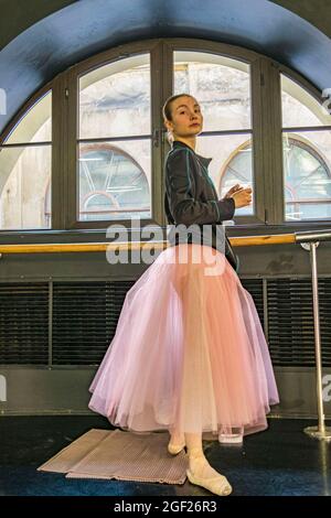 Une jeune danseuse de ballet vêtue d'un tutu pratique sa danse dans une salle de répétition à Saint-Pétersbourg en vue d'un spectacle. Banque D'Images