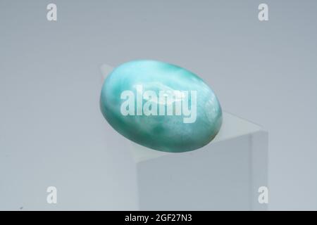 Pierre de larimar naturelle sur un stand sur fond blanc Banque D'Images