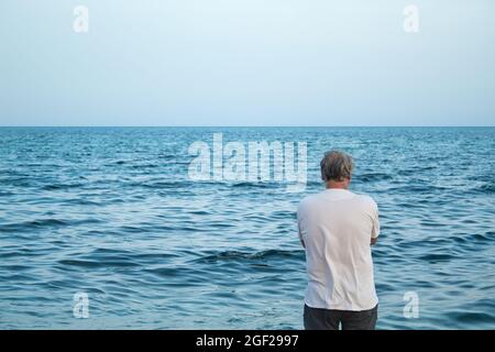 vue de l'arrière de l'homme mûr avec des cheveux gris appréciant sur la mer Banque D'Images