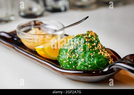 Salade d'algues Chukka avec sauce aux arachides, citron et graines de sésame. Gros plan, mise au point sélective Banque D'Images