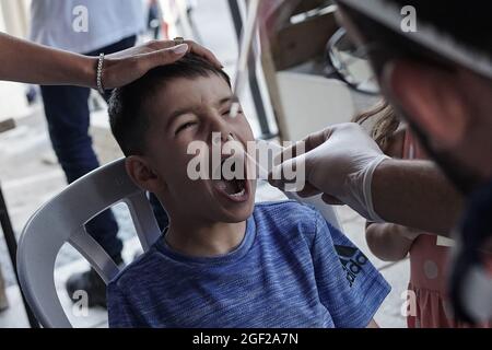 Jérusalem, Israël. 23 août 2021. Les ambulanciers paramédicaux de Magen David Adom, en tant qu'organisation israélienne de la Croix-Rouge et chef de file du SGE, effectuent des tests rapides d'Antigen Covid-19 sur les non vaccinés âgés de plus de trois ans. Un résultat négatif accorde un Green Pass de 24 heures et un accès à des lieux publics intérieurs et à des événements, conformément aux nouvelles restrictions imposées par le gouvernement. Une passe verte à long terme est accordée uniquement aux personnes entièrement vaccinées ou récupérées du coronavirus. Israël combat une quatrième vague de COVID-19 composée principalement de la variante Delta. Crédit : NIR Amon/Alamy Live News Banque D'Images