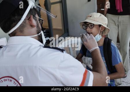 Jérusalem, Israël. 23 août 2021. Les ambulanciers paramédicaux de Magen David Adom, en tant qu'organisation israélienne de la Croix-Rouge et chef de file du SGE, effectuent des tests rapides d'Antigen Covid-19 sur les non vaccinés âgés de plus de trois ans. Un résultat négatif accorde un Green Pass de 24 heures et un accès à des lieux publics intérieurs et à des événements, conformément aux nouvelles restrictions imposées par le gouvernement. Une passe verte à long terme est accordée uniquement aux personnes entièrement vaccinées ou récupérées du coronavirus. Israël combat une quatrième vague de COVID-19 composée principalement de la variante Delta. Crédit : NIR Amon/Alamy Live News Banque D'Images