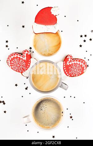 Trois tasses de café en forme de bonhomme de neige avec biscuit au gingembre chapeau de père Noël et mitaines. Banque D'Images