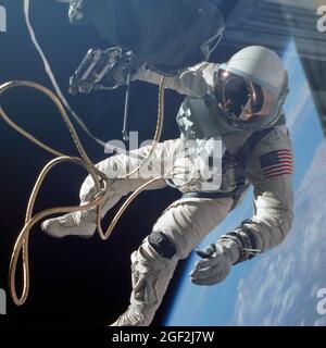 (3 juin 1965) --- l'astronaute Edward H. White II, pilote de la mission orbitale terrestre de quatre jours Gemini IV, flotte dans la gravité zéro de l'espace à l'extérieur de l'engin spatial Gemini IV. Blanc porte un espace spécialement conçu; et la visière du casque est plaquée or pour le protéger contre les rayons non filtrés du soleil. Il porte également un kit d'oxygène d'urgence. Il est fixé à l'engin spatial par une ligne ombilicale de 25 pieds et une ligne d'attache de 23 pieds, tous deux enveloppés de ruban doré pour former un seul cordon. Dans sa main droite se trouve une unité d'auto-manœuvrabilité manuelle (HHSMU) avec laquelle il contrôle ses mouvements dans l'espace Banque D'Images