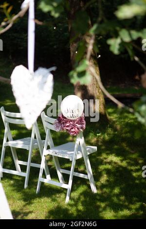 chaises de mariage, rangées à l'extérieur dans le parc, avec décorations faites à la main. Photo de haute qualité Banque D'Images