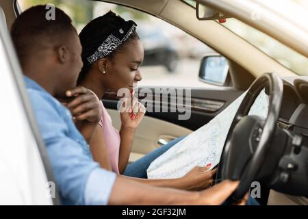 Une famille noire confuse s'est perdue, en vérifiant la carte, en voyageant en voiture Banque D'Images