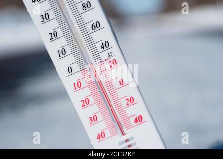 En hiver ou au printemps, le thermomètre repose sur la neige Et indique une température négative par temps froid. Conditions météorologiques avec faible débit d'air et ambie Banque D'Images