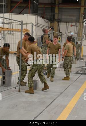 210821-N-OX321-1012 STATION AÉRIENNE NAVALE DE SIGONELLA, ITALIE (AOÛT 21, 2021) les Seabees, affectés au département des travaux publics de la Station aérienne navale de Sigonella, installent des séparateurs dans un hangar pour créer un espace multi-opération à bord de la Station aérienne navale de Sigonella afin de soutenir la mission du ministère de la Défense visant à faciliter le départ et le déplacement en toute sécurité des citoyens américains, les titulaires de visas d'immigration spéciaux, Et les populations afghanes vulnérables d'Afghanistan, le 21 août 2021. (É.-U. Photo de la marine par le spécialiste des communications de masse de 1re classe Kegan E. Kay) Banque D'Images