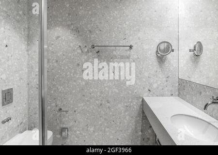 Décoration moderne et minimaliste, salle de bains avec accessoires chromés et carrelage gris Banque D'Images