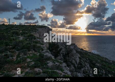 MELLIEHA, MALTE - 04 janvier 2021 : un coucher de soleil, vu du sommet d'une falaise le long de la côte dans la partie nord de Mellieha, Malte. Station radar visible n Banque D'Images