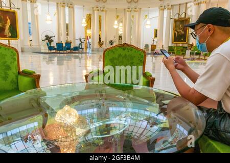 Nice, France, Homme chinois assis dans Hall, regardant le Smart Phone à l'intérieur de salon Royal, Hôtel de luxe Negresco, le tourisme de smartphone Banque D'Images