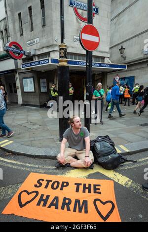 Londres, Royaume-Uni. 23 août 2021. Un manifestant est assis devant la station de métro Leicester Square tandis que des activistes climatiques de l'extinction Rebellion ont manifesté à Covent Garden. Le groupe a annoncé qu'il allait organiser des manifestations dans la capitale pendant les deux prochaines semaines, afin de sensibiliser les gens aux effets des grandes entreprises sur le changement climatique. Credit: Stephen Chung / Alamy Live News Banque D'Images