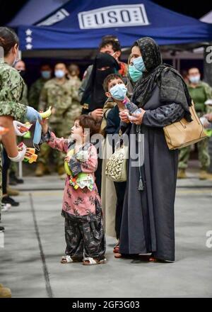 Sigonella, Italie. 22 août 2021. Une famille afghane évacuée de Kaboul attend de la nourriture et des masques après son arrivée à la base aérienne navale de Sigonella le 22 août 2021 à Sigonella, en Italie. NAS Sigonella fournit un hébergement temporaire aux personnes évacuées d'Afghanistan dans le cadre de l'opération alliés refuge. Credit: Planetpix/Alamy Live News Banque D'Images