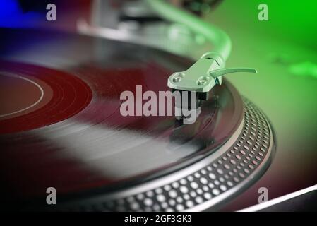 vue rapprochée d'un disque en vinyle en cours de lecture sur une platine lumineuse colorée Banque D'Images