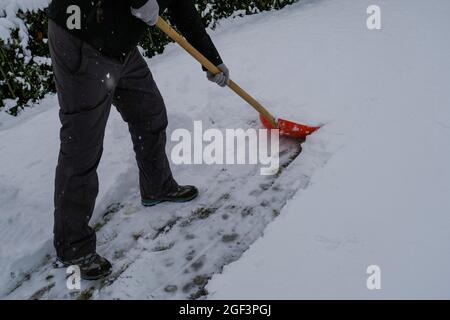 personne avec une pelle nettoyant la rue hors de neige. Tempête de neige, temps d'hiver. Banque D'Images