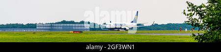 Ryan Air Ryanair Boeing 737 800 avion décollage de l'aéroport de Stansted Essex Angleterre avec le hangar d'entretien en arrière-plan bleu ciel jour Banque D'Images