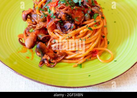 Spaghetti à l'octopus, sauce tomate, olives et câpres. Recette typique de la cuisine napolitaine, en Italie. Prêt à manger Banque D'Images