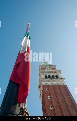 Vue verticale depuis le bas du clocher de la place Saint-Marc à Venise et un drapeau italien Banque D'Images