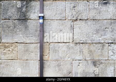 Conducteur d'éclairage métallique fixé à l'ancien mur en pierre Banque D'Images