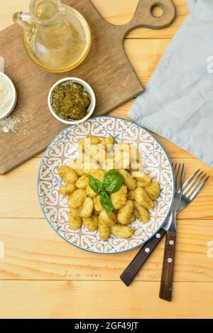 Assiette avec sauce savoureuse au gnocchi et au pesto sur fond de bois Banque D'Images