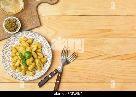 Assiette avec sauce savoureuse au gnocchi et au pesto sur fond de bois Banque D'Images