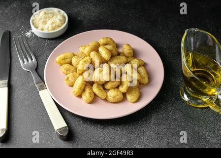 Assiette avec délicieux gnocchi de pesto sur fond sombre Banque D'Images