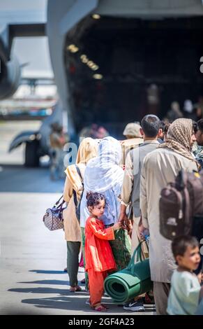 Les familles attendent de monter à bord d'un Boeing C-17 Globemaster III de la US Air Force lors d'une évacuation à l'aéroport international Hamid Karzaï, à Kaboul, en Afghanistan, le 22 août. Les membres du service des États-Unis aident le ministère d'État à procéder à un retrait ordonné du personnel désigné en Afghanistan. (É.-U. Photo du corps marin par Sgt. Samuel Ruiz via American PhotoArchive/Alamy) Banque D'Images