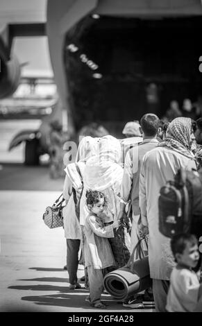 Les familles attendent de monter à bord d'un Boeing C-17 Globemaster III de la US Air Force lors d'une évacuation à l'aéroport international Hamid Karzaï, à Kaboul, en Afghanistan, le 22 août. Les membres du service des États-Unis aident le ministère d'État à procéder à un retrait ordonné du personnel désigné en Afghanistan. (É.-U. Photo du corps marin par Sgt. Samuel Ruiz via American PhotoArchive/Alamy) Banque D'Images