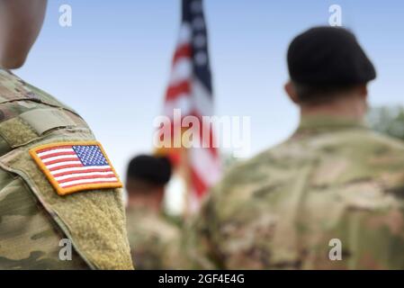 SOLDATS AMÉRICAINS. Armée AMÉRICAINE. Drapeau américain sur l'uniforme militaire américain. Soldats sur le terrain de parade depuis l'arrière. Fête des anciens combattants. Memorial Day. Banque D'Images