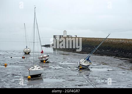 Petits bateaux reposant dans la boue à marée basse dans le port de Granton sur le Firth of Forth, Édimbourg, Écosse, Royaume-Uni. Banque D'Images