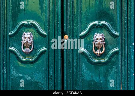 Porte knocker comme une tête antique à l'entrée d'une maison, ancienne poignée de porte en métal ornée, Italie Banque D'Images