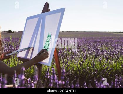 Femme peint sur toile dans le champ de lavande Banque D'Images