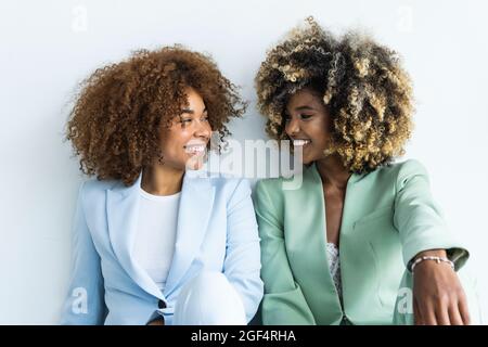 Femmes d'affaires souriantes dans un blazer regardant l'une l'autre Banque D'Images