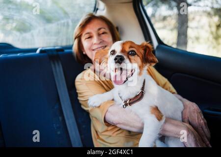 Femme âgée avec un chien assis en voiture Banque D'Images