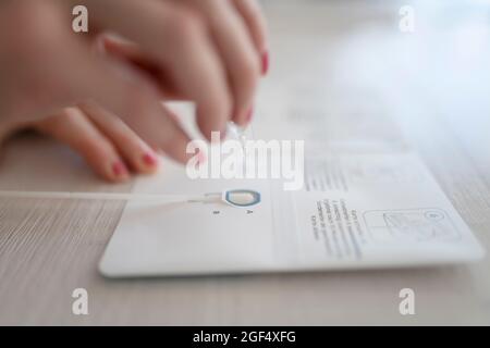 Femme prenant le test rapide COVID-19 avec outil de diagnostic à la maison Banque D'Images