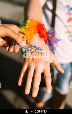 Main de l'homme représentant un drapeau arc-en-ciel sur la main d'un ami mâle Banque D'Images