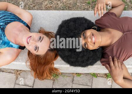 Des amies souriantes couchés sur le banc Banque D'Images