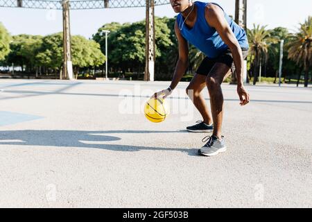 Un joueur de basket-ball masculin joue sur un terrain de sport Banque D'Images