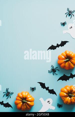 Joyeux halloween concept de vacances. Cadre de décorations d'halloween, chauves-souris, fantômes, citrouilles, araignées sur fond bleu. Carte d'invitation Halloween m Banque D'Images