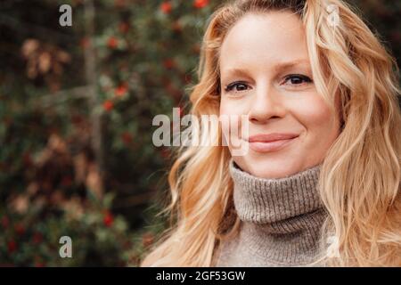 Belle femme blonde souriante portant un col roulé Banque D'Images