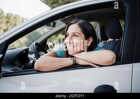 Belle jeune femme regardant loin de la fenêtre de voiture Banque D'Images