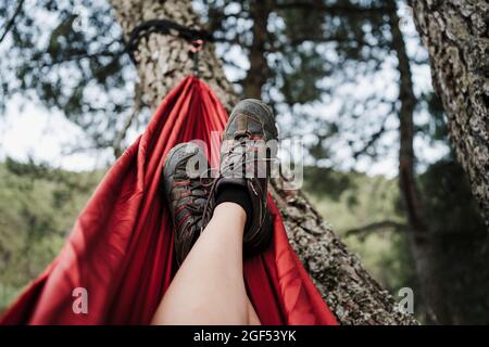 Femme avec les pieds vers le haut se détendant sur le hamac Banque D'Images